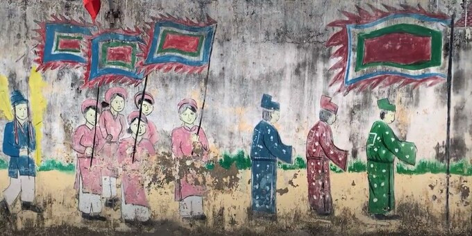 Một bức tranh tường ghi lại cảnh vinh quy bái tổ, khắc họa truyền thống khoa bảng tại đường làng.