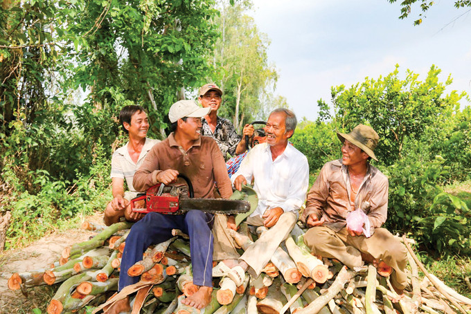Lão nông Trương Văn Kiềm (thứ 2 từ trái qua) cùng các thành viên trong đội đi cưa cây làm nhà cho người nghèo. Ảnh: Internet
