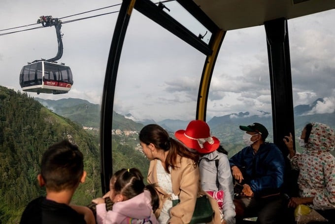 Du khách đi cáp treo tham quan quần thể du lịch Fansipan Legend của Sun World xuống núi, với tầm nhìn ra thung lũng Mường Hoa. Ảnh: New York Times