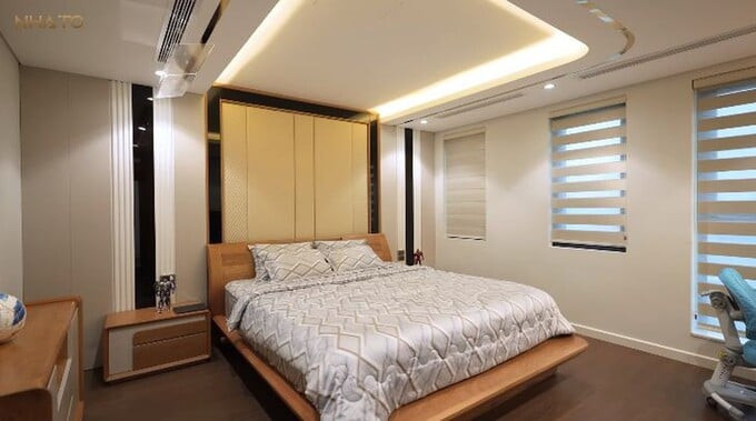 Phòng ngủ master sử dụng tông màu kem chủ đạo với nội thất gỗ óc chó kết hợp da