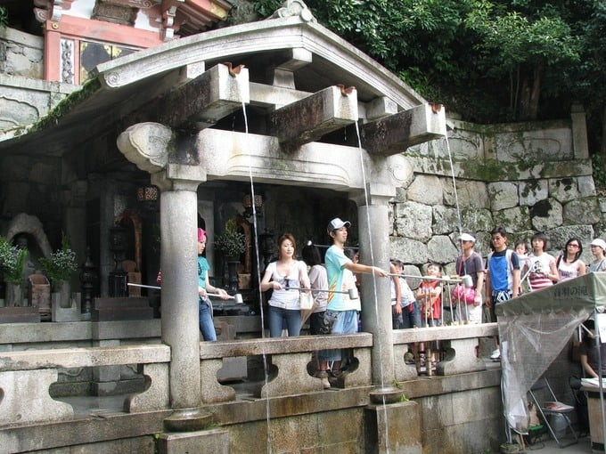 Du khách lấy nước thiêng dưới chân thác Otowa