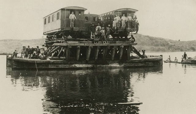 Toa xe của đoàn tàu được vận chuyển qua sông bằng phà