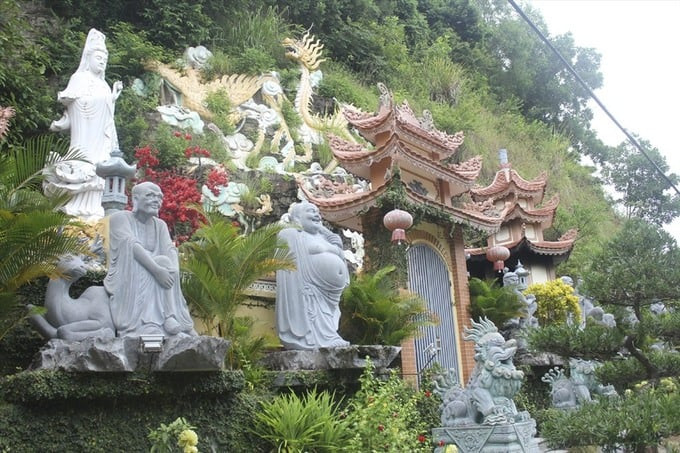 Bên ngoài chùa, tượng Phật Bà Quan Âm từ bi đứng nghiêm trên đá núi