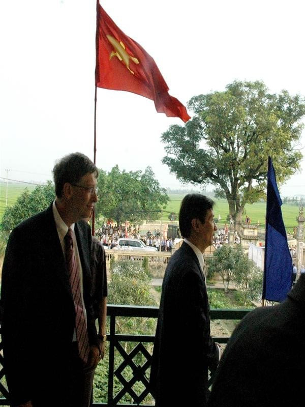 Bill Gates đứng trên ban công tầng 2 nhà bưu điện xã Tam Sơn ngắm khung cảnh cây đa, bến nước, sân đình Việt Nam