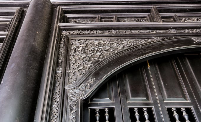 Khung cửa và các cánh cửa làm bằng gỗ quý, đều chạm trổ tinh xảo các hoa lá rồng phượng như tạo thêm sức sống cho mặt tiền của căn nhà