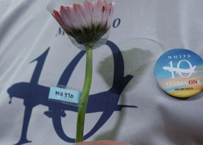 Người thân nạn nhân cầm hoa trong một buổi tưởng nhớ 10 năm máy bay MH370 mất tích