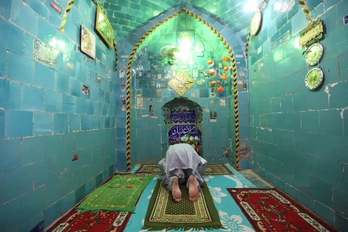 Một người đàn ông cầu nguyện bên trong đền thờ Imam Mahdi tại nghĩa trang Wadi al-Salam