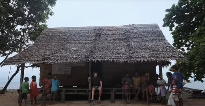 Luke (áo đen) ngồi trước cửa một căn nhà trên đảo Utupua và trò chuyện với người dân