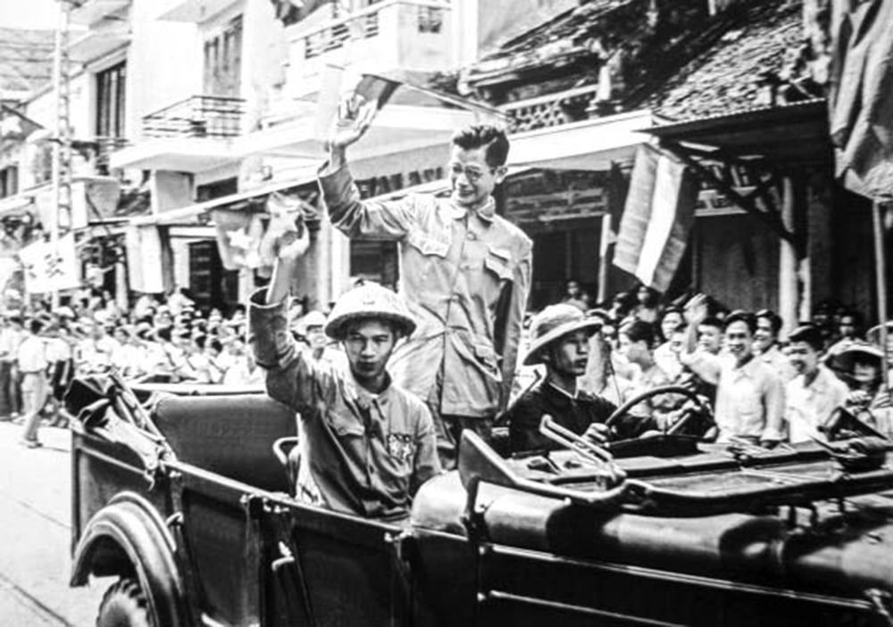 Bác sĩ Trần Duy Hưng (người đứng trên xe) trong đoàn quân tiến vào tiếp quản Thủ đô ngày 10/10/1954. Ảnh: Hội Nghệ sỹ Nhiếp ảnh Việt Nam/Đào Trình