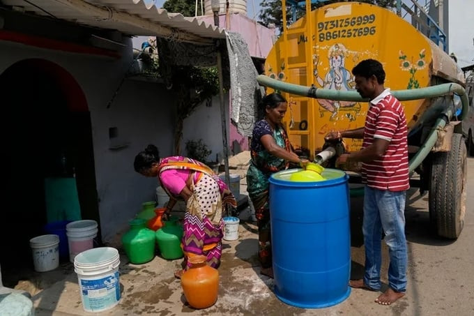 Người dân lấy nước từ xe bồn chở nước tư nhân ở Bengaluru, Ấn Độ. Ảnh: AP