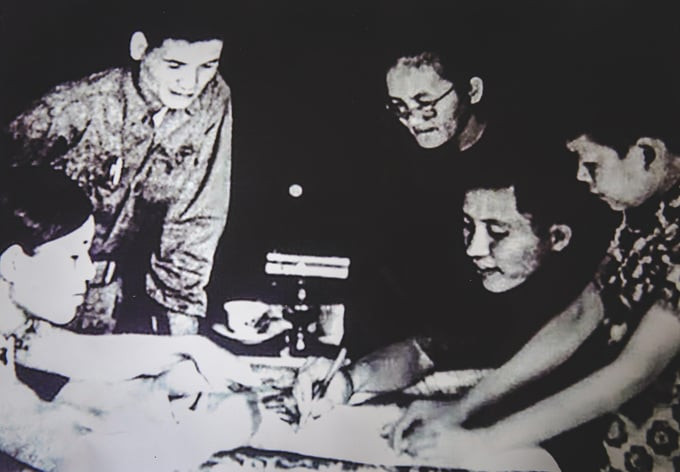 Má Sáu Ngẫu (đeo kính) chỉ đường trên bản đồ cho quân Giải phóng (Trung đoàn trưởng Nguyễn Huy Hiệu – thứ hai từ phải sang). Ảnh tư liệu