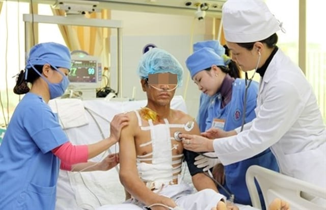 Trung tướng Lê Thu Hà (áo trắng, bên phải) cùng các đồng nghiệp khám và chăm sóc sức khỏe cho bệnh nhân sau mổ. Ảnh: Trọng Đức/TTXVN