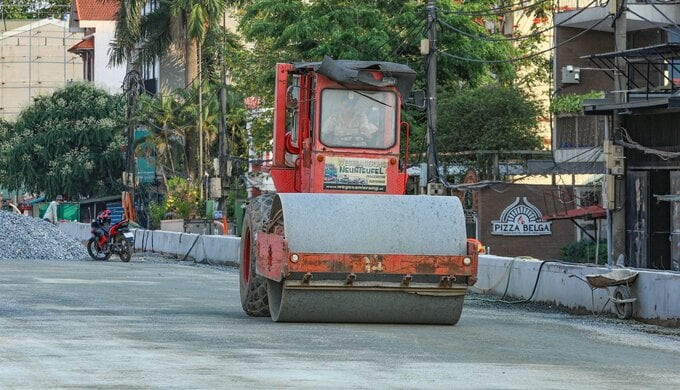 Máy lu tiến hành lèn đường để trải nhựa. Ảnh: Báo Giao thông