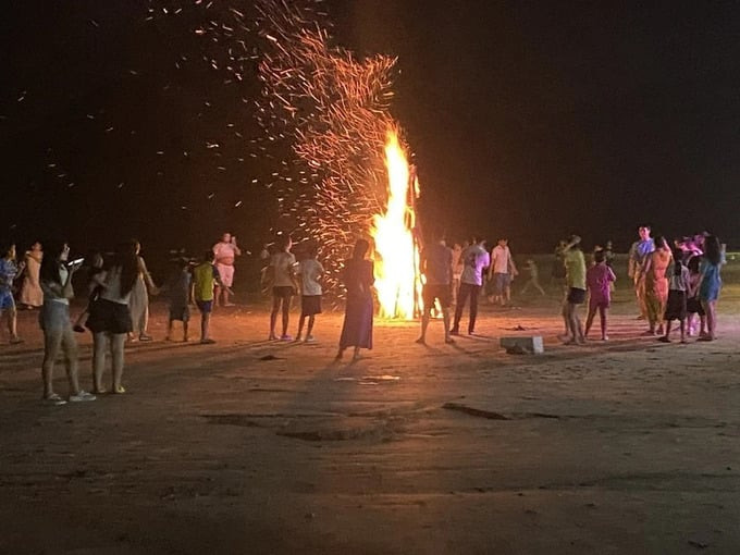Du khách tham gia hoạt động đốt lửa trại tại bãi biển. Ảnh: QH/Báo Dân Việt