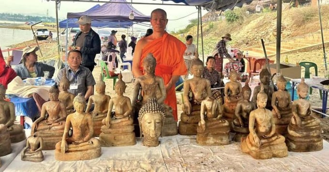 Một nhà sư địa phương chụp ảnh với tượng Phật được tìm thấy ở Bokeo (Ảnh: Khattayabaramee)