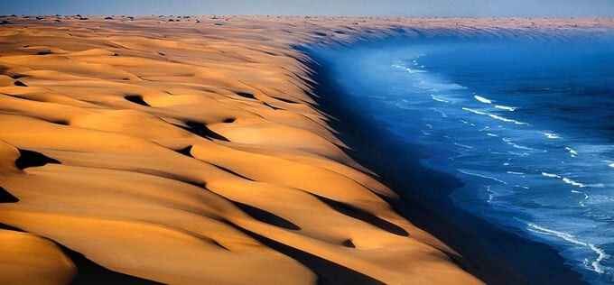 Vẻ đẹp điển hình kỳ lạ của sa mạc Namib với cồn cát đỏ bên làn nước đại dương biếc xanh (Ảnh: travelnetbook)