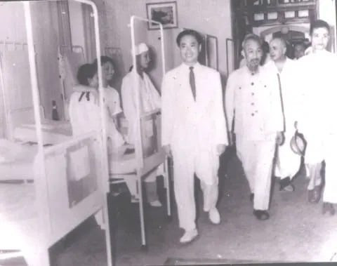 Giáo sư Tôn Thất Tùng (người mặc complet trắng bên trái) dẫn Chủ tịch Hồ Chí Minh đi thăm Bệnh viện Việt Đức sau ngày Hà Nội giải phóng. Ảnh tư liệu