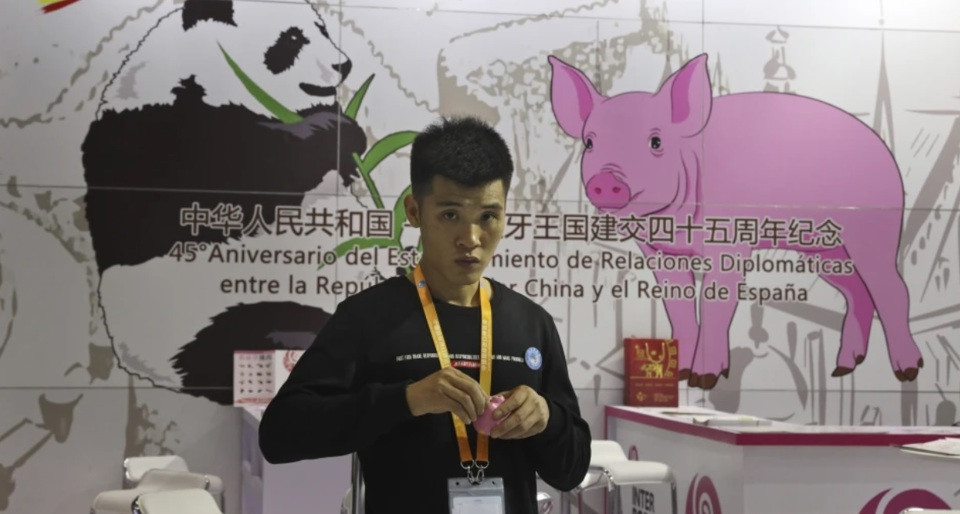 Một nhân viên quảng bá sản phẩm tại gian hàng thịt lợn nhập khẩu của Tây Ban Nha tại Hội chợ triển lãm nhập khẩu quốc tế Trung Quốc ở Thượng Hải. Ảnh: AP