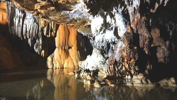 Dưới lòng động, nhiều mạch nước ngầm len lỏi qua các khe đá, tạo thành những vũng nước trong vắt như mặt gương. Ảnh: Báo Lao Động