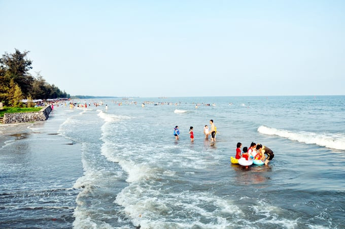 Du khách vui chơi, tắm biển tại bãi biển Trà Cổ. Ảnh: Báo Quảng Ninh