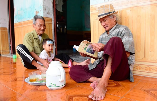 Ông Nguyễn Văn Đoán (bên phải) kể về ngôn ngữ cổ của làng Đa Chất. Ảnh: Công an Nhân dân