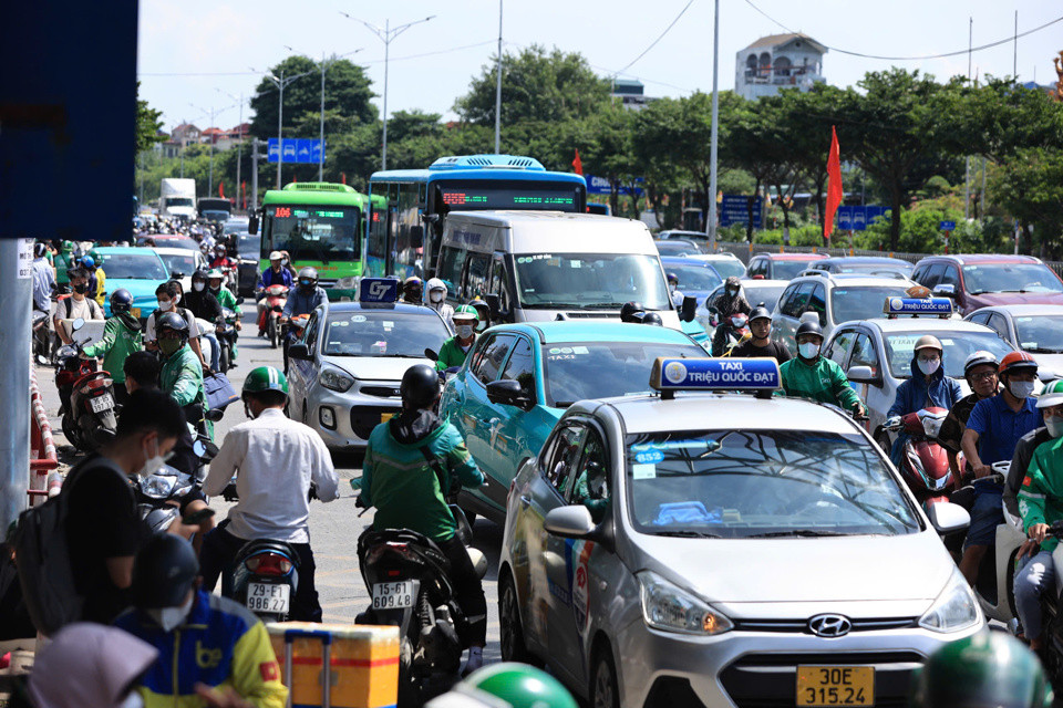 Trên quốc lộ 1A, xe máy, ô tô chen chân nhích vào nội thành.