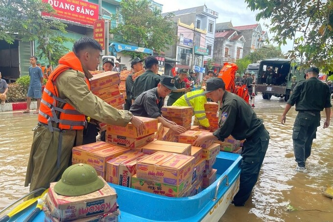 Lực lượng chức năng hỗ trợ người dân bị ảnh hưởng do bão lũ. Ảnh: Tiền phong