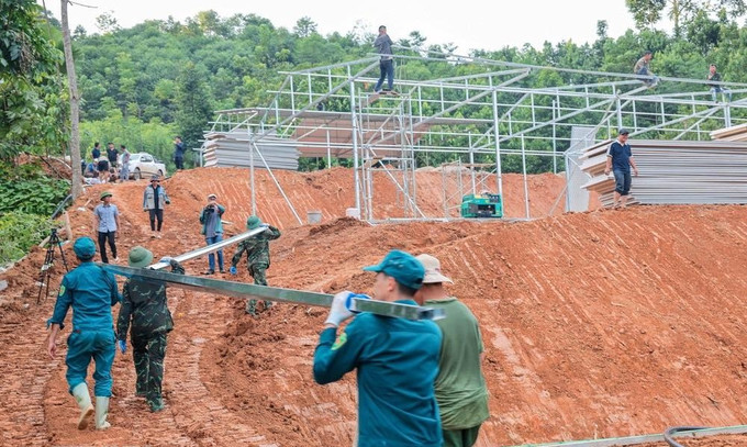 Các đơn vị ngày đêm triển khai nhà tạm cho người dân thôn. Ảnh: TTXVN