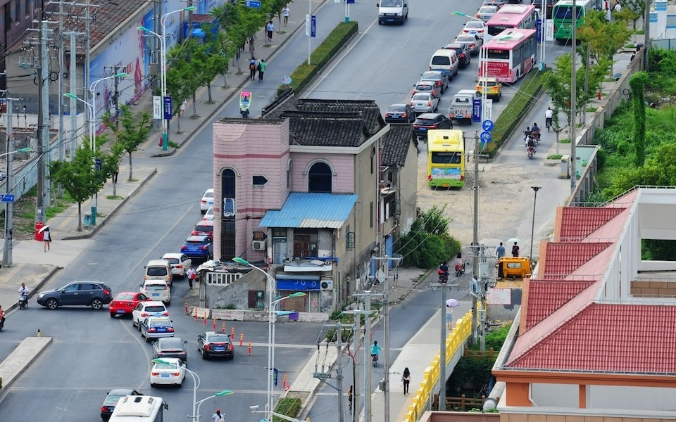 Căn nhà của ông Trương Tân Quốc nằm trơ trọi giữa đường quốc lộ. Ảnh: Sohu