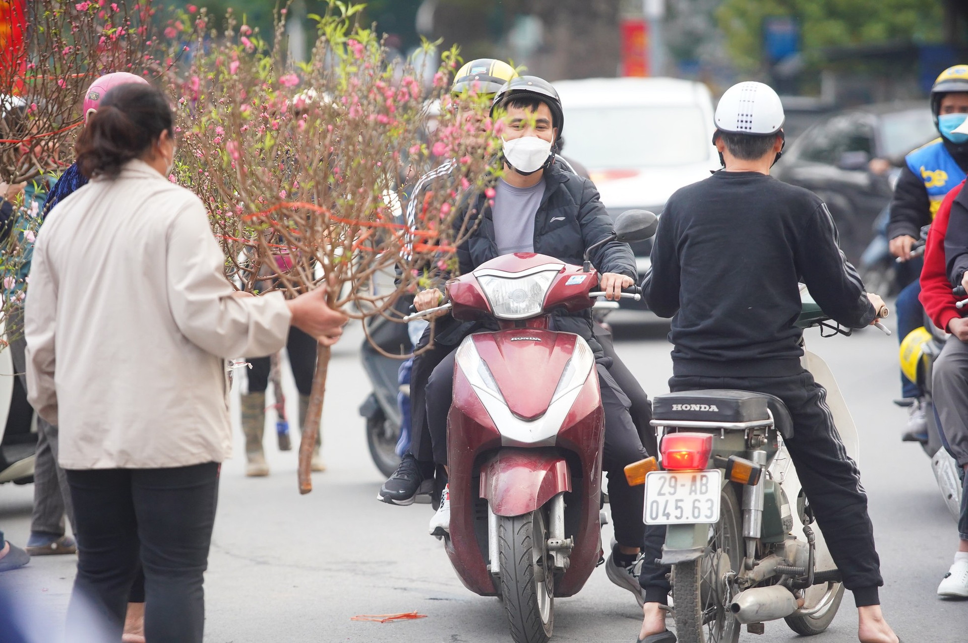 Ngày đầu kỳ nghỉ Tết Nguyên đán, người dân hồ hởi xuống phố 'săn' cành đào, cây quất ảnh 1