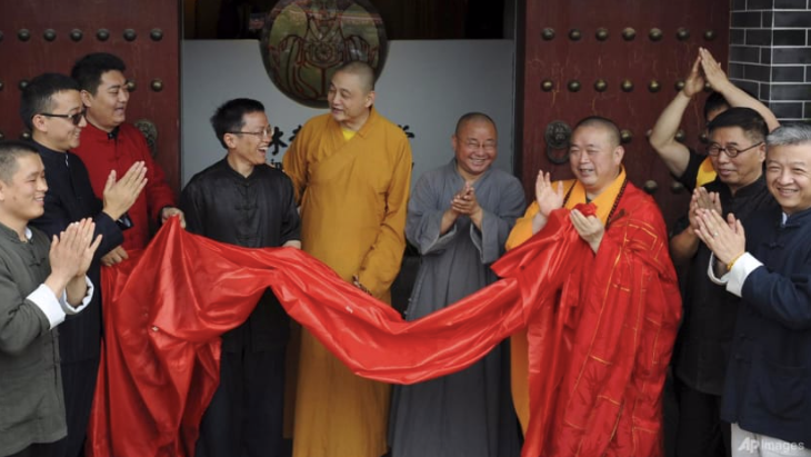 Sư Thích Vĩnh Tín (áo cà sa vàng và đỏ) dự lễ khai trương một trung tâm thiền đô thị ở tỉnh Thiểm Tây, tây bắc Trung Quốc, năm 2015. (Ảnh: AP) screen-shot-2025-07-28-at-71432-am.png