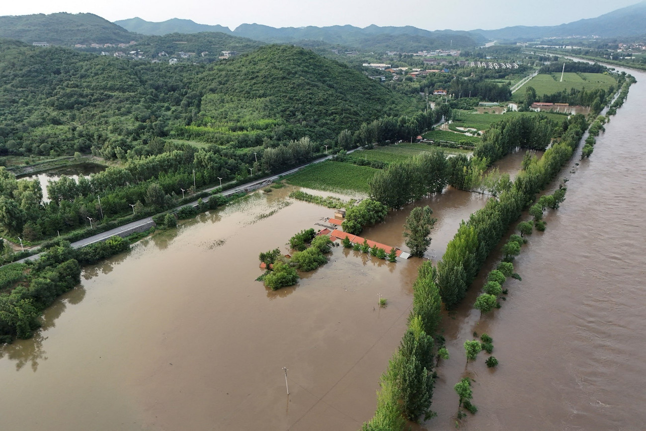 Nước sông tràn bờ ở Mật Vân ngày 28/7. (Ảnh: Reuters) ihl5f2gz2rjmzpbirgqyrpi2ty.jpg
