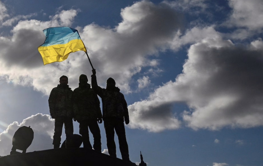 Nhóm lính Ukraine giương cờ khi đứng trên chiếc xe tăng Challenger 2 ở miền tây nam nước Anh, năm 2023. (Ảnh: Reuters) screen-shot-2025-08-18-at-72851-am.png