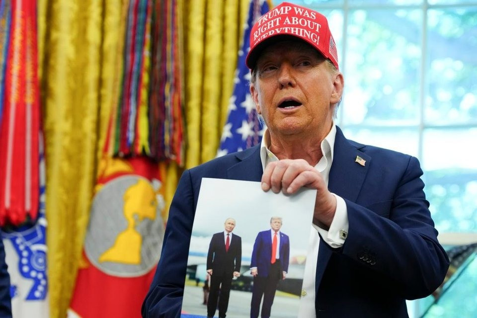 Tổng thống Mỹ Donald Trump khoe ảnh chụp chung với Tổng thống Nga Vladimir Putin. (Ảnh: NY Times) c3270e7a8c515a18b972943ca3ac6338.jpg
