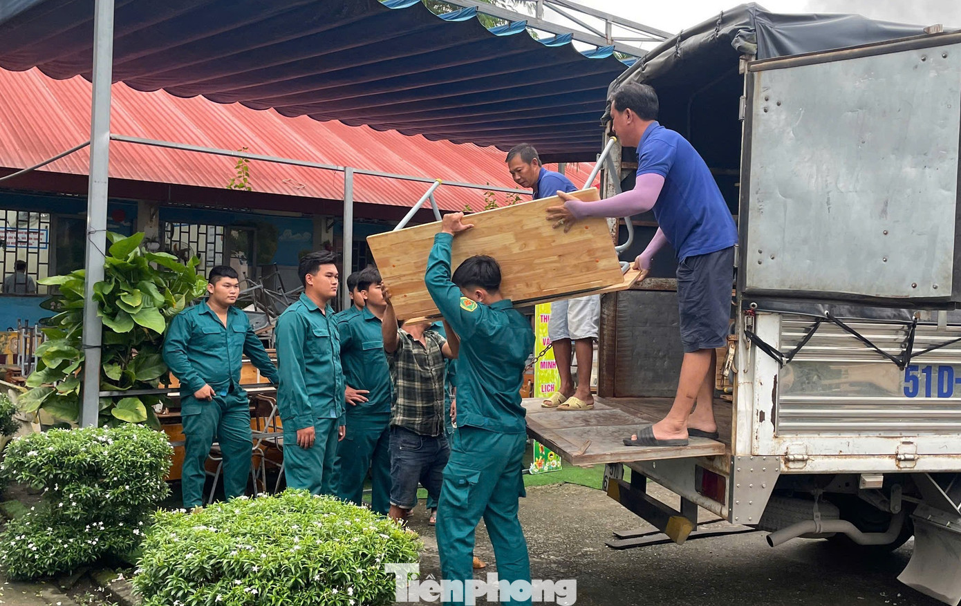 Dân quân phường tham gia hỗ trợ vận chuyển bàn ghế. tp-vinh-tan-5.jpg