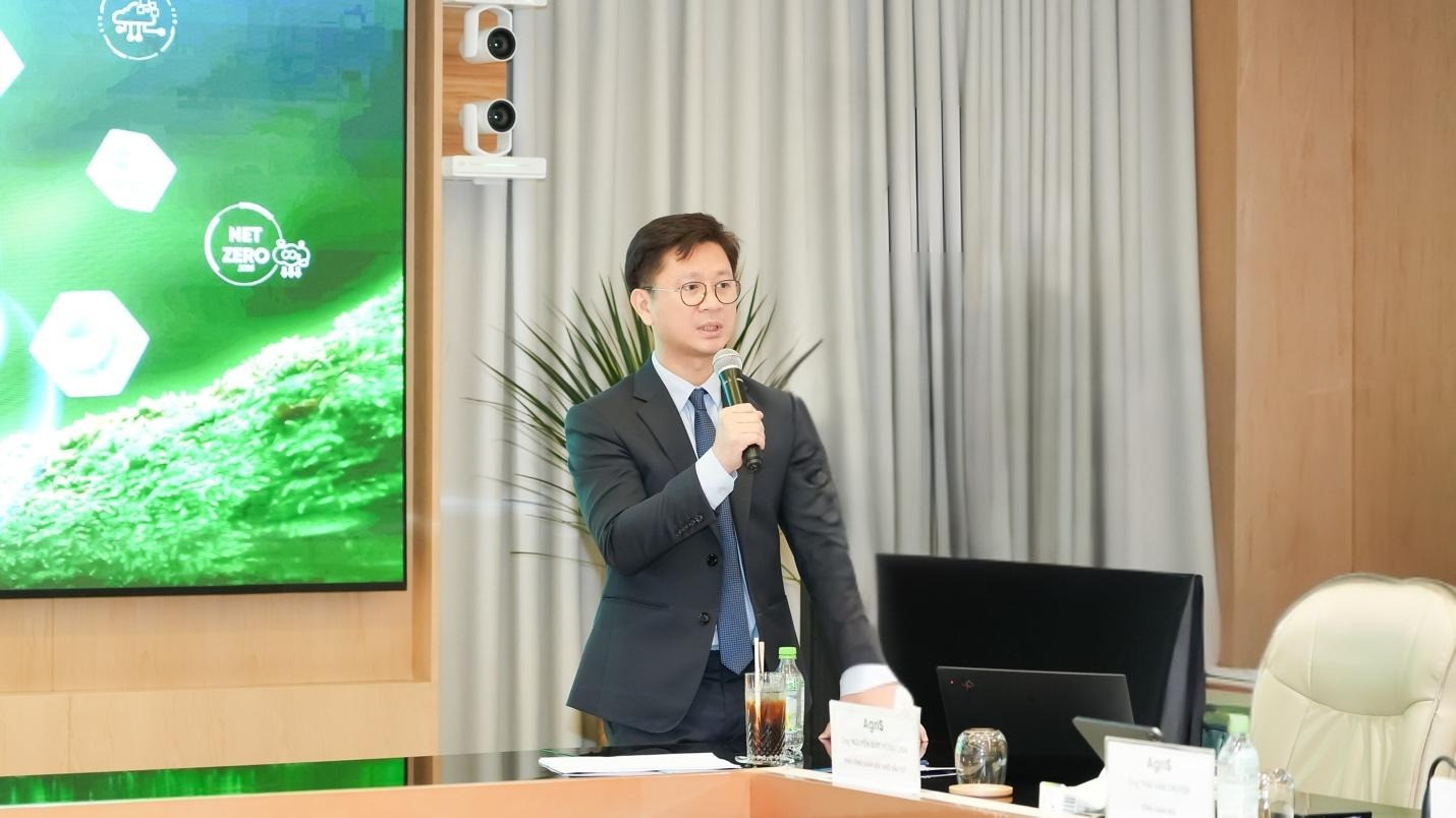 A person in a suit holding a microphone Description automatically generated