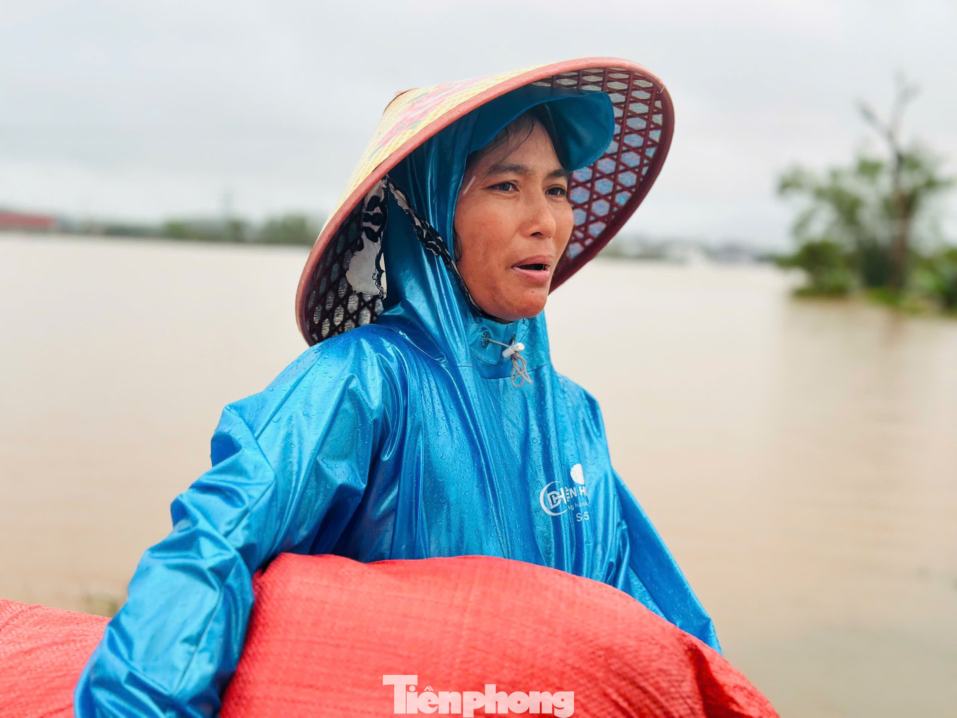 Chị Dương Thị Xuyến mang túi đựng quần áo cứu trợ về mặc vì nhà ngập sâu, quần áo ướt sạch. tp-sjhs.jpg