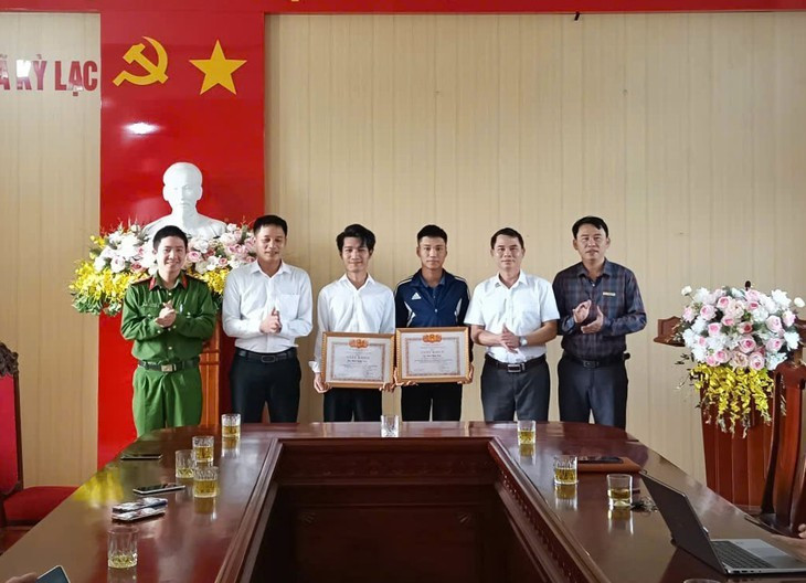 Nam sinh Phan Bình Minh (áo khoác đen) cùng anh Phan Lương Nhật nhận giấy khen của Chủ tịch UBND xã Kỳ Lạc vì đã có hành động dũng cảm cứu người đuối nước. z7223445925489f9f93308eb10145ce49bab030501499e-17631091061501774412202.jpg