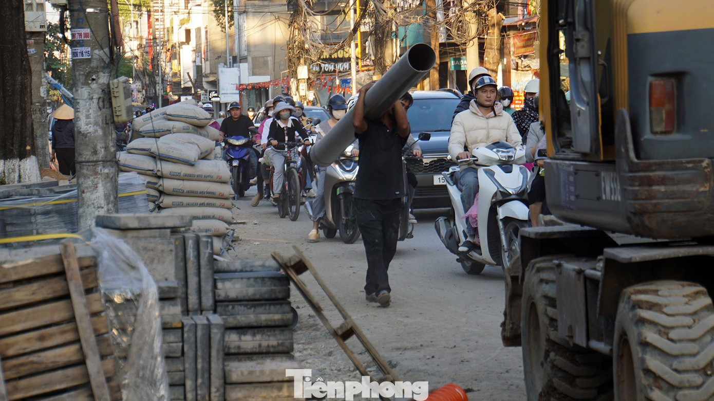 Đá lát vỉa hè, xi măng, vật liệu xây dựng được tập kết dưới lòng đường. Nhiều công nhân không được trang bị thiết bị bảo hộ lao động. tp-via-he8.jpg