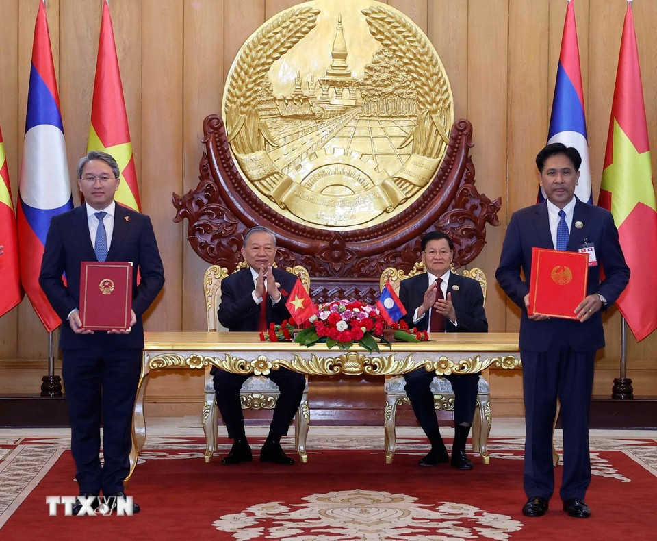 Hai nhà lãnh đạo chứng kiến lễ trao các văn kiện hợp tác Việt Nam - Lào. Ảnh: TTXVN le-ky.jpg