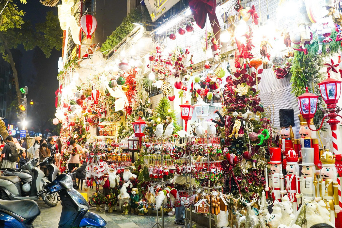 Từ ngày cuối tháng 11, phố Hàng Mã, Hàng Lược (quận Hoàn Kiếm) đã khoác lên bộ áo rực rỡ quen thuộc của mùa Giáng sinh. Dãy dài cửa hàng đồng loạt bày bán các sản phẩm trang trí với mẫu mã bắt mắt, từ cây thông, vòng nguyệt quế, đèn led đến tượng ông già Noel, người tuyết hay các tiểu cảnh nhà tuyết thu nhỏ. z7299511746184-bcf9b6d7b26f2c3b6920bb8451a6ad0d.jpg