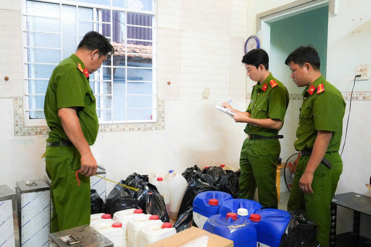 Lực lượng công an kiểm đếm tang vật phục vụ sản xuất nước hoa giả bị thu giữ trong quá trình khám xét. z7413335357386-6eda8996a537f8dc6bfbca55b4d5bab7.jpg