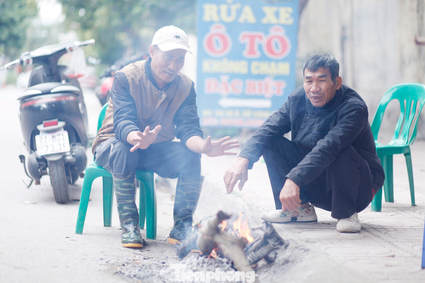 Ông Đỗ Văn Thủy (bên trái) nhóm lửa sưởi ấm. Ảnh: Nguyễn Thắng tp-1.jpg