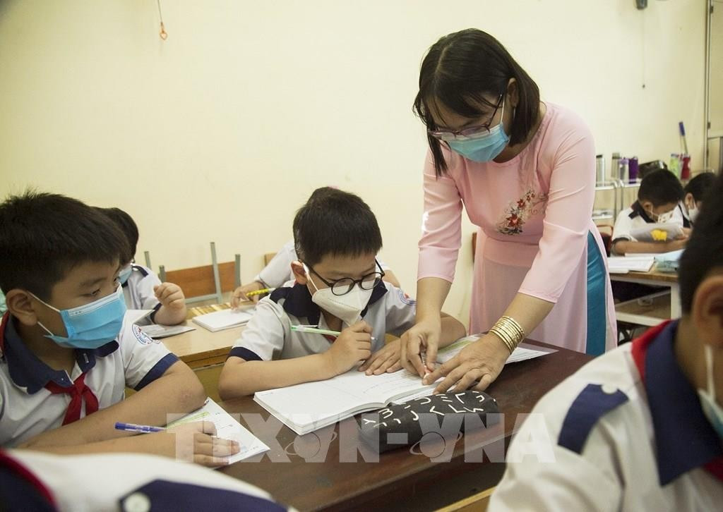 Giáo viên đang hướng dẫn học sinh làm bài tập (Ảnh minh họa) thay.jpg