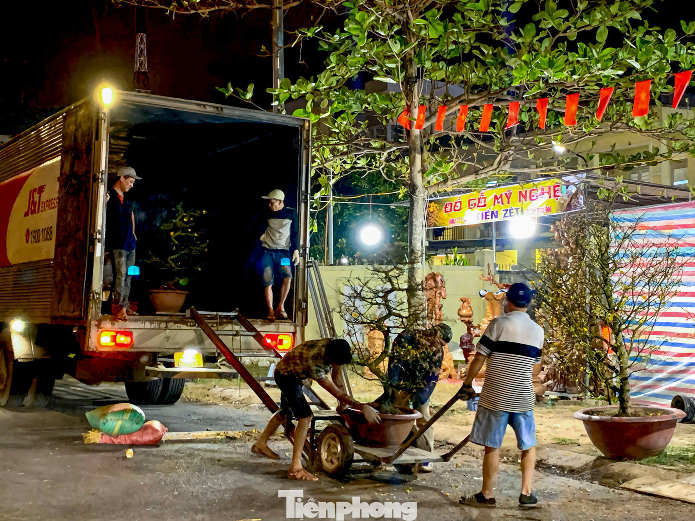 Dù đã khuya, nhiều tiểu thương vẫn tất bật bốc xếp, vận chuyển từng chậu hoa lên xe cho khách. tp-thuccanhhoa-2.jpg