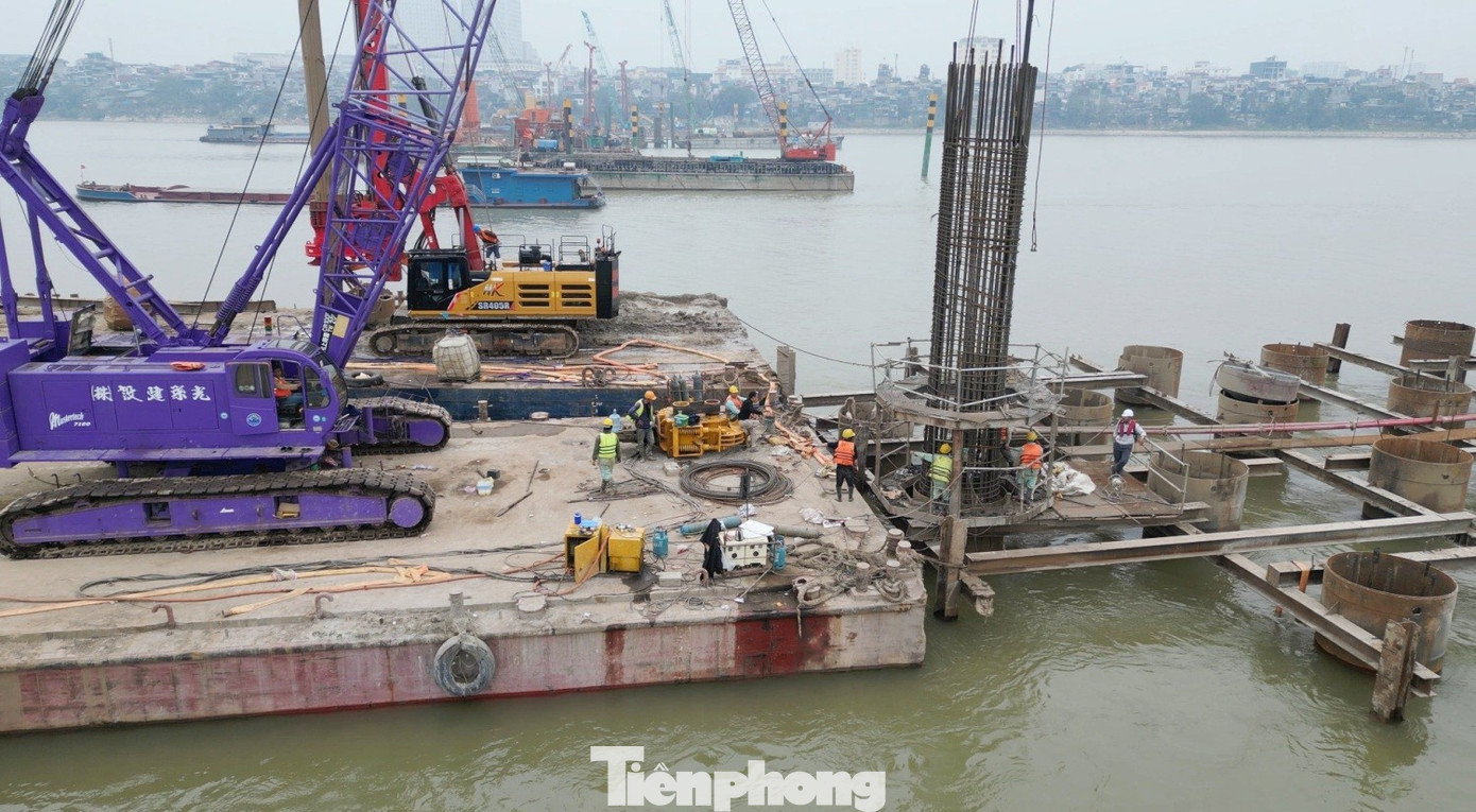 Công nhân và máy móc đang thi công hạng mục đổ trụ cầu Trần Hưng Đạo giữa lòng sông Hồng. tp-3-9626.jpg