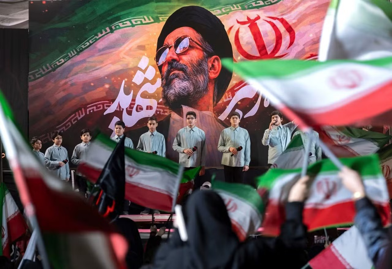 Một nhóm thanh niên Iran biểu diễn dưới bức chân dung của cố Lãnh tụ Tối cao Iran Ayatollah Ali Khamenei trong một cuộc biểu tình ủng hộ chính phủ ở trung tâm Tehran hôm 6/4. (Ảnh: NurPhoto) Hơn 14 triệu người Iran sẵn sàng hy sinh để bảo vệ đất nước - Ảnh 1.
