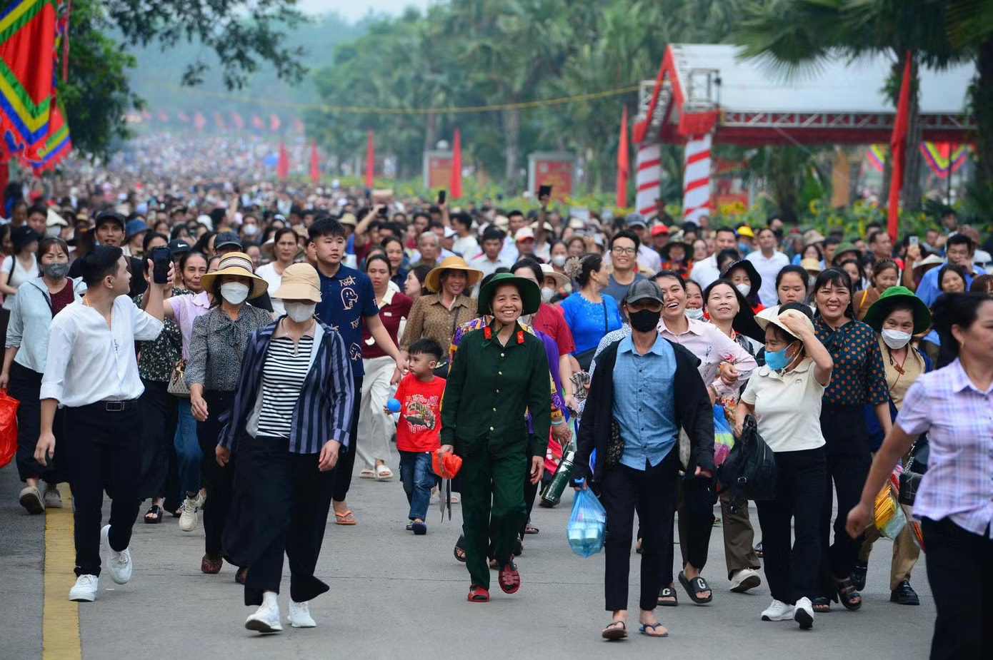 Bên ngoài, các trục đường chính và lối lên núi Nghĩa Lĩnh trở thành “biển người”. Từng nhóm gia đình, bạn bè, du khách từ nhiều tỉnh, thành đổ về. Dòng người nhích từng bước lên Đền Hùng - Ảnh 3.