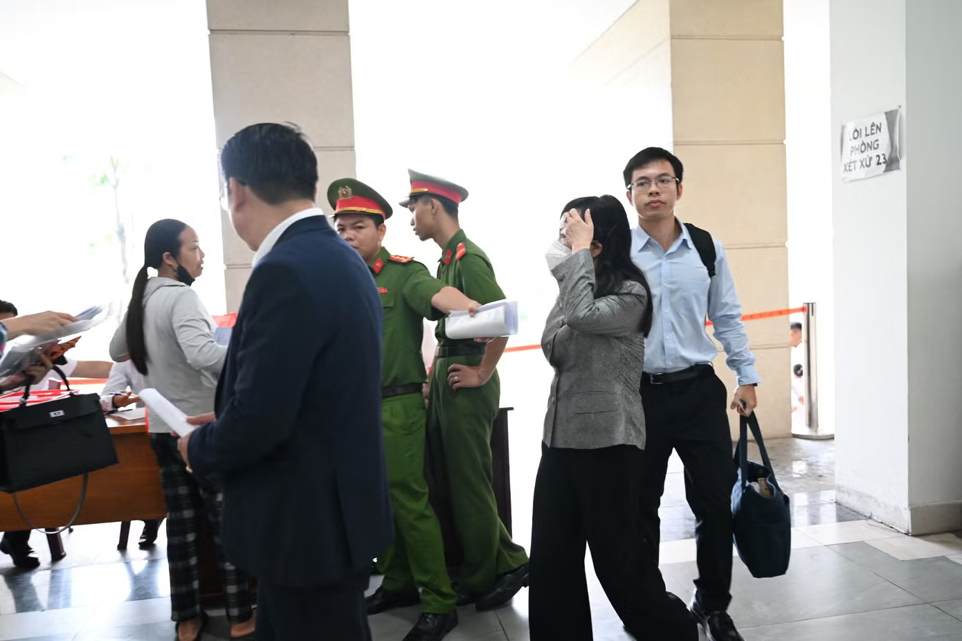 Lực lượng công an kiểm tra an ninh trước khi cho bà Tiến qua cửa lên Hội trường xét xử. Hình ảnh cựu Bộ trưởng Nguyễn Thị Kim Tiến tại phiên tòa xét xử vụ sai phạm trong đầu tư cơ sở 2 BV Bạch Mai, Việt Đức - Ảnh 2.