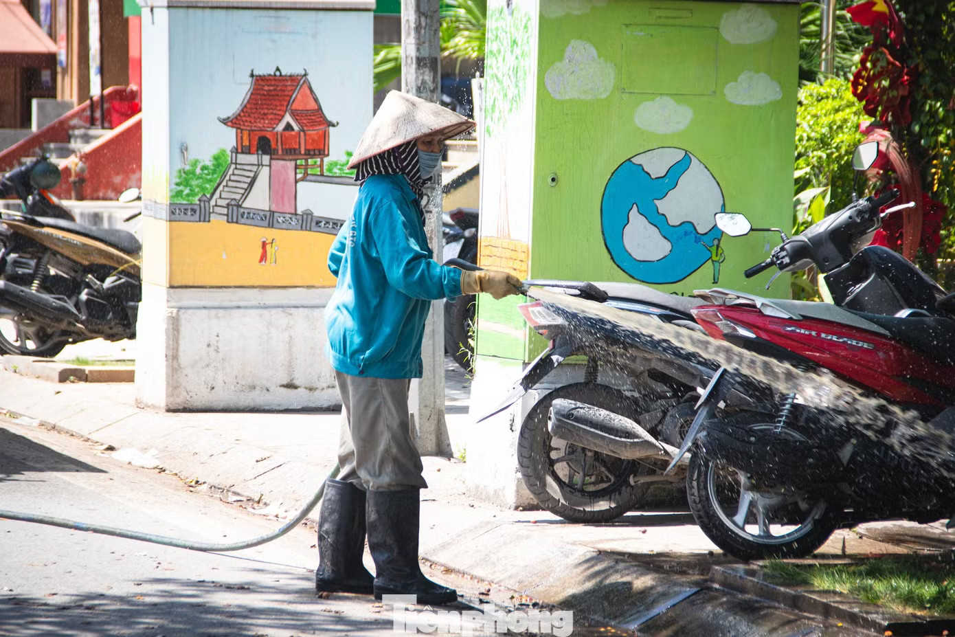 Nhiều tiểu thương dọc các tuyến phố liên tục tưới nước ra vỉa hè và lòng đường để giảm nhiệt. Mặt đường gần 50 độ C, lao động tự do kiệt sức giữa đợt nắng đỉnh điểm ở Hà Nội - Ảnh 10.
